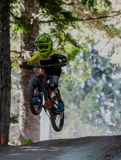 Child hitting a jump on a mountain bike